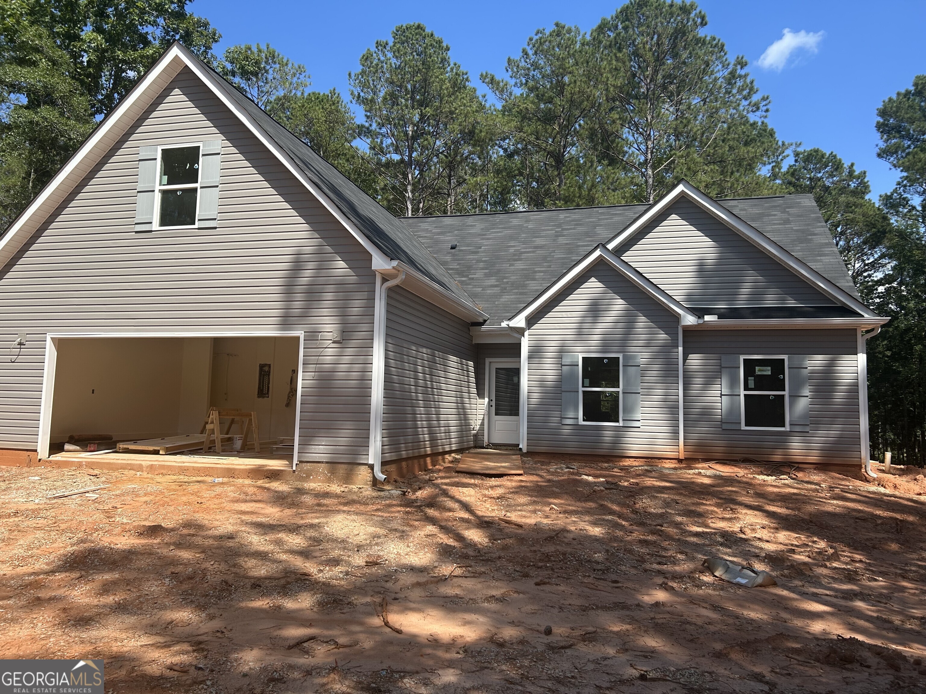 a front view of house with yard and trees in the background