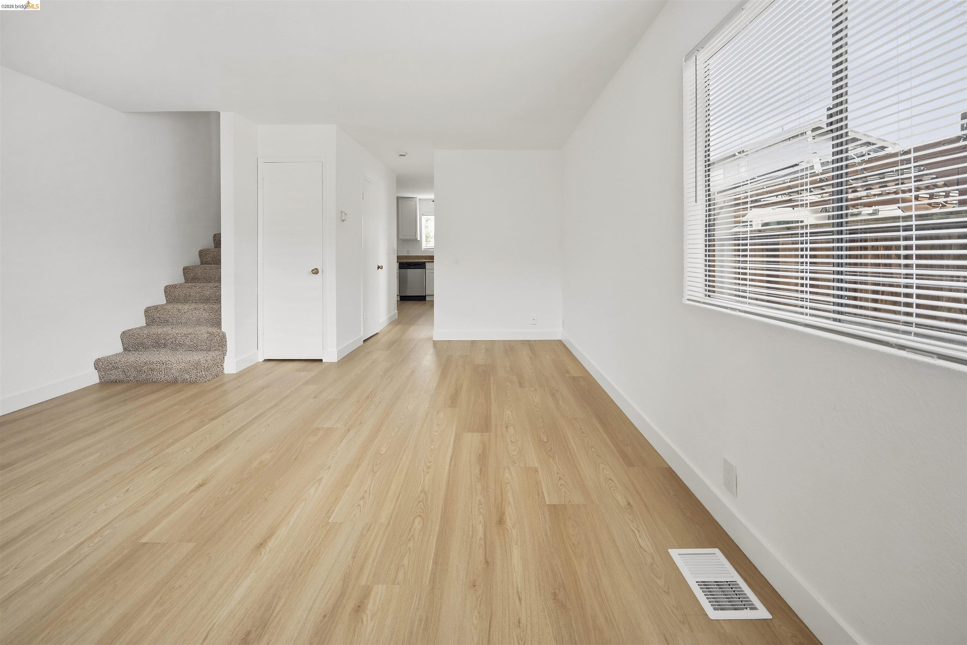 10933 Julius Street, Unit D Oakland, CA 94605 - Photo 2 of 28 a view of a room with wooden floor and stairs