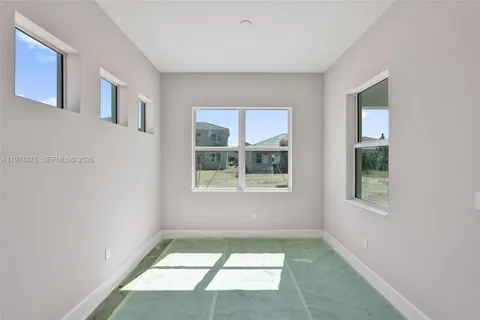 a sign board with a house in the background