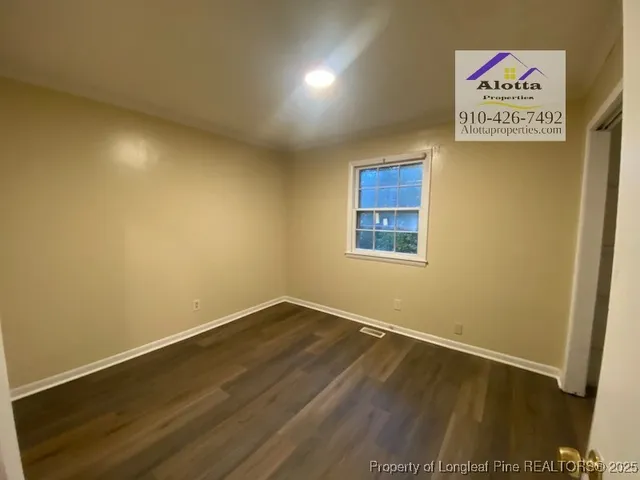 a view of an empty room with wooden floor