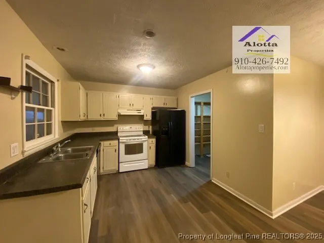 a kitchen with granite countertop a refrigerator and a sink