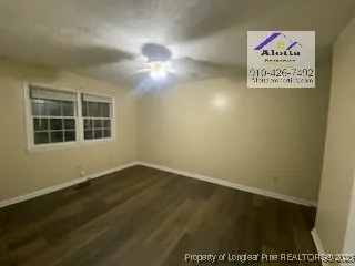 an empty room with a ceiling fan and window