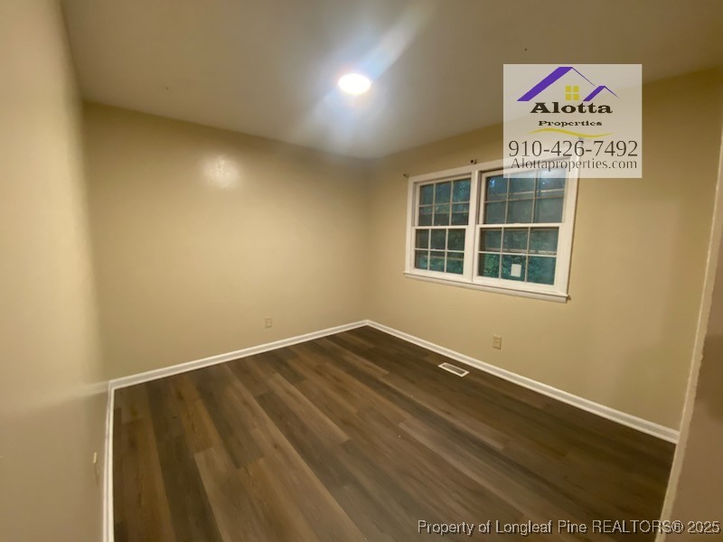 733 Goodyear Drive Spring Lake, NC 28390 - Photo 9 of 13 a view of an empty room with wooden floor and a window