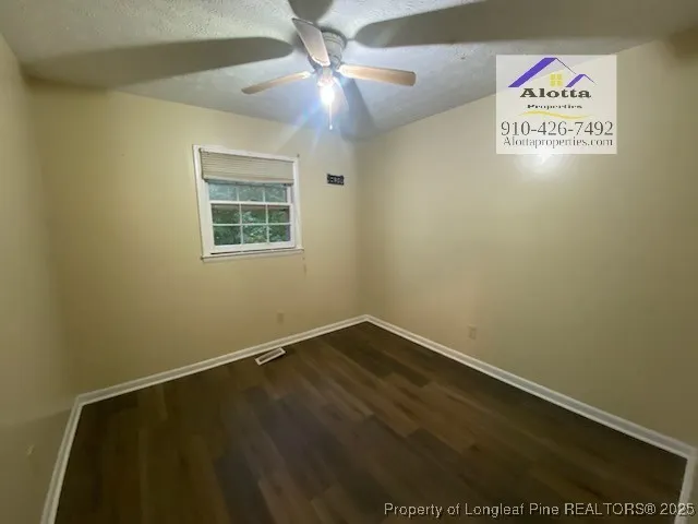an empty room with a ceiling fan and window
