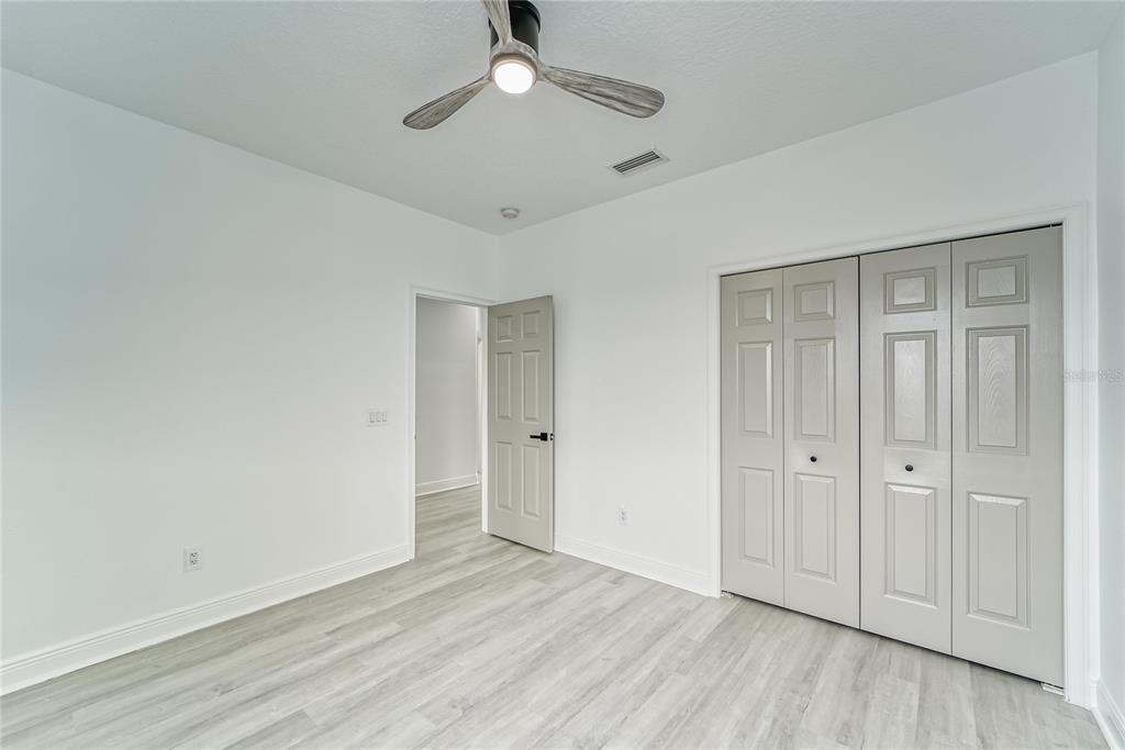 5718 Sea Turtle Place Apollo Beach, FL 33572 - Photo 14 of 81 an empty room with wooden floor cabinet and windows
