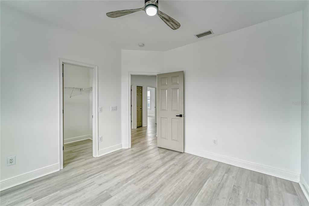 5718 Sea Turtle Place Apollo Beach, FL 33572 - Photo 21 of 81 an empty room with wooden floor a ceiling fan and windows