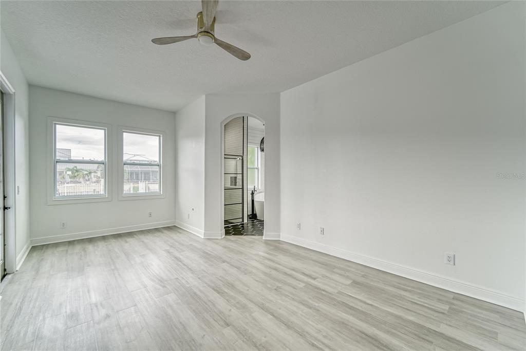 5718 Sea Turtle Place Apollo Beach, FL 33572 - Photo 40 of 81 an empty room with wooden floor chandelier fan and windows