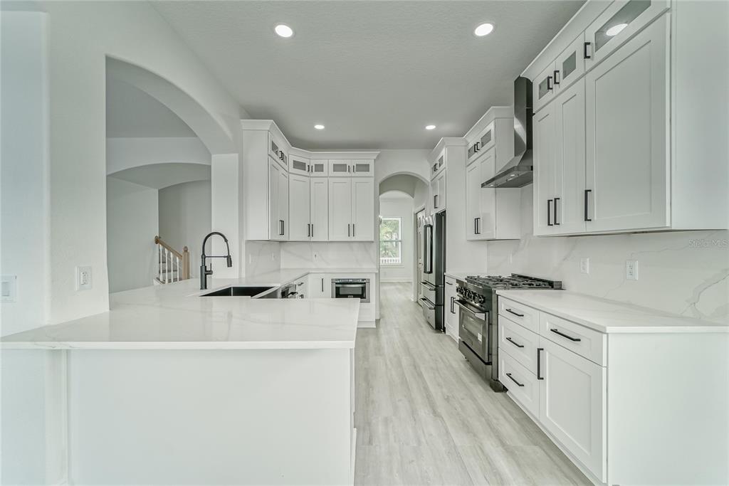 5718 Sea Turtle Place Apollo Beach, FL 33572 - Photo 70 of 81 a kitchen with stainless steel appliances granite countertop a sink stove and refrigerator
