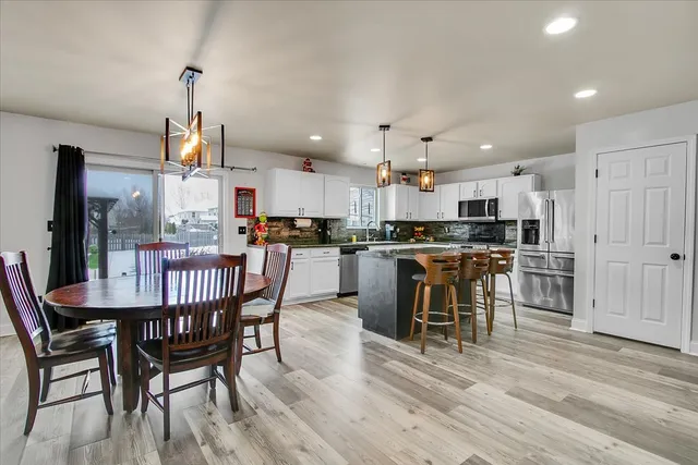 a kitchen with stainless steel appliances kitchen island granite countertop a dining table chairs and granite counter tops