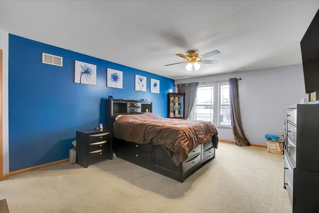 a spacious bedroom with a bed and a chandelier
