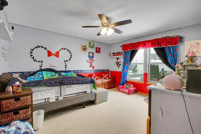 a bedroom with baby bed toys and a window