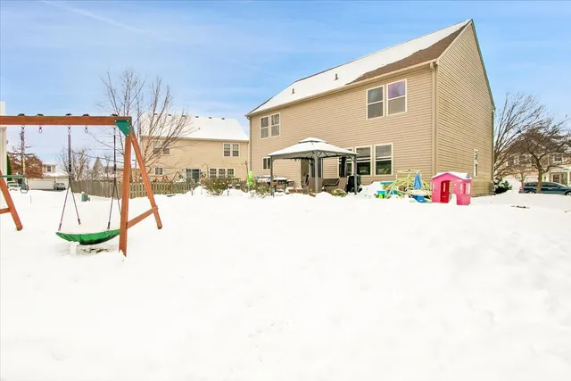 a view of a white house with snow on the road