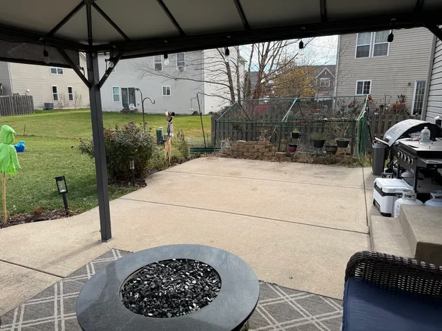 a view of a patio with table and chairs under an umbrella