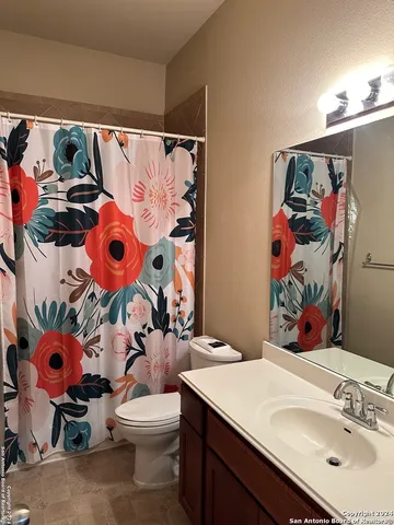 a bathroom with a sink mirror vanity and toilet