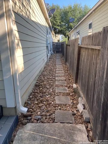 a view of a pathway with wooden fence