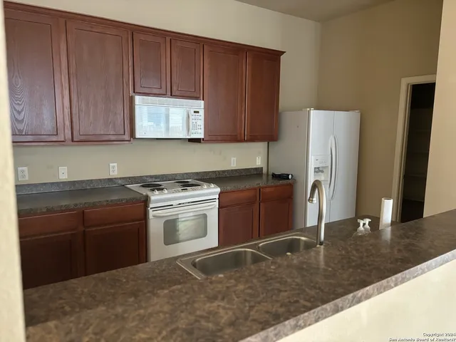 a kitchen with a refrigerator sink and cabinets