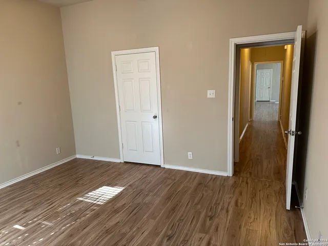 a view of a room with wooden floor and a bathroom