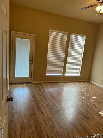 an empty room with wooden floor and windows