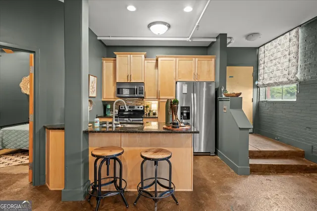 a kitchen with stainless steel appliances granite countertop a refrigerator and a stove top oven