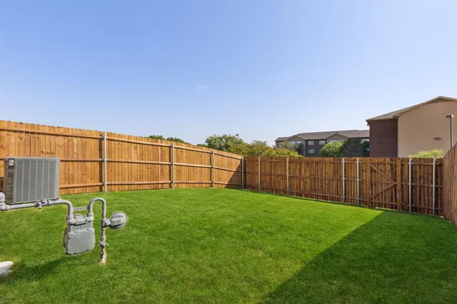 a view of a backyard with wooden fence