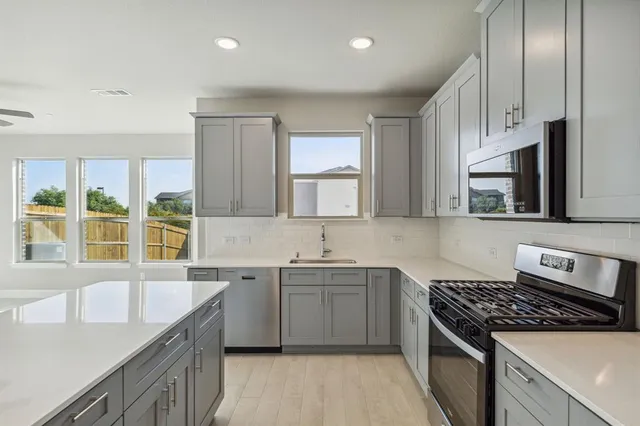 a kitchen with a sink stove top oven and cabinets