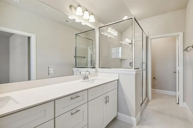 a spacious bathroom with a shower sink and mirror