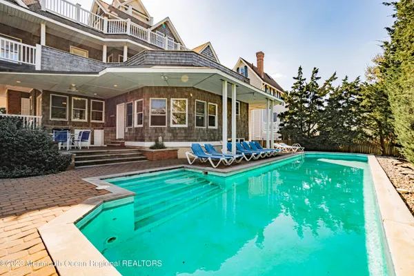 a front view of a house with swimming pool having outdoor seating