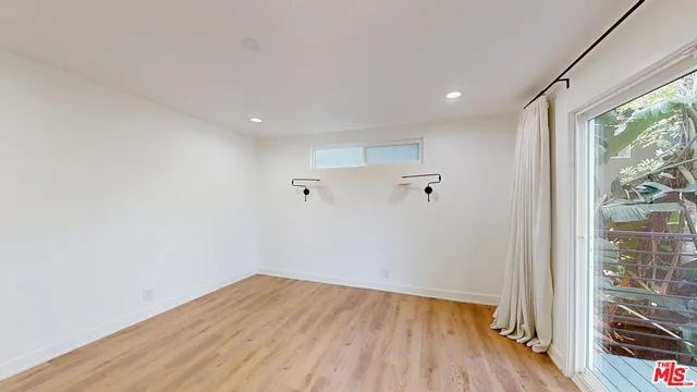 a view of a big room with wooden floor and windows