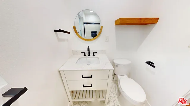 a bathroom with a sink toilet and mirror