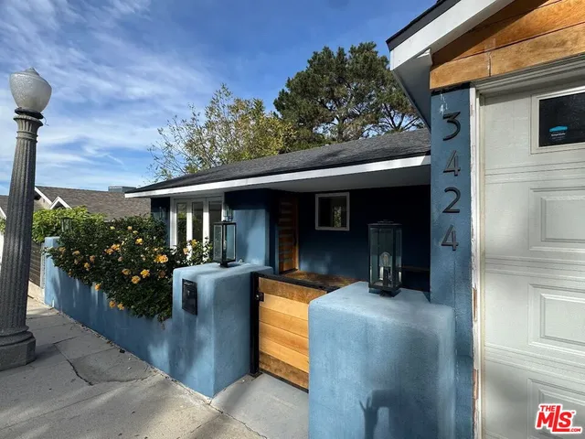 a view of a patio with couches chairs potted plants and floor to ceiling window