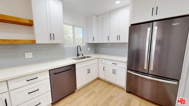 a kitchen with white cabinets and stainless steel appliances