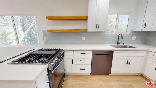a kitchen with a stove a sink and a microwave