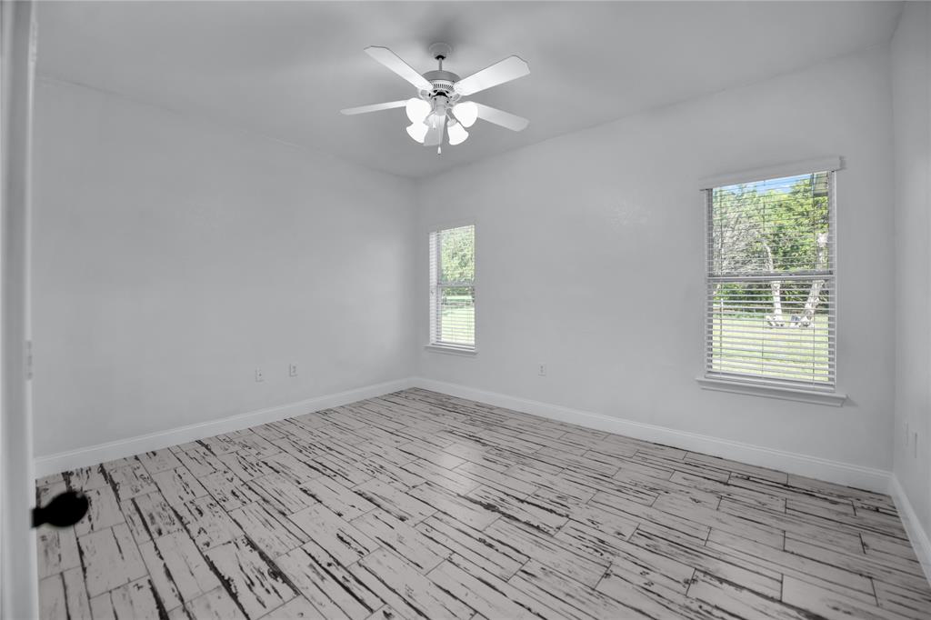 400 Deer Valley Road Weatherford, TX 76085 - Photo 19 of 40 a view of an empty room with wooden floor and a window
