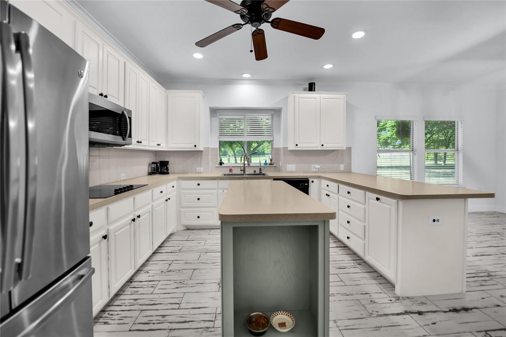 400 Deer Valley Road Weatherford, TX 76085 - Photo 5 of 40 a kitchen with stainless steel appliances kitchen island granite countertop a sink a stove a refrigerator cabinets and a window
