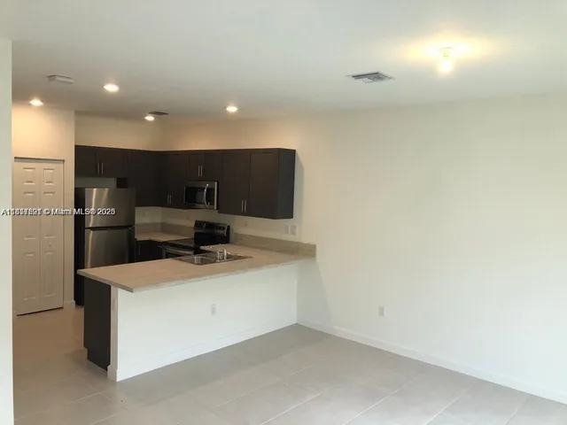 a view of kitchen appliances and wooden floor