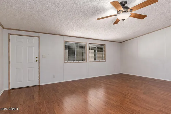 a view of an empty room with window and wooden floor
