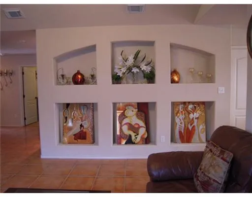 a living room with furniture and wall paintings