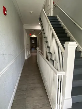 a view of a hallway with wooden floor and stairs