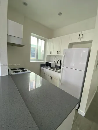 a kitchen with refrigerator and window