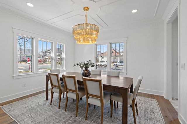 a living room with furniture a fireplace and a chandelier