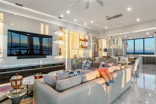 a living room with furniture and floor to ceiling windows