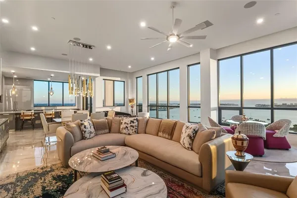 a kitchen with stove a sink a counter top space and living room view