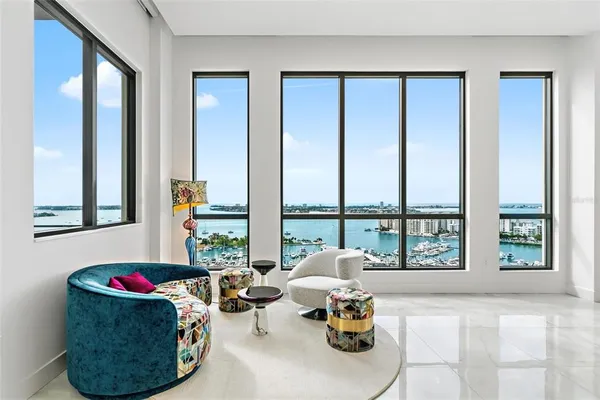 a living room with furniture and floor to ceiling windows