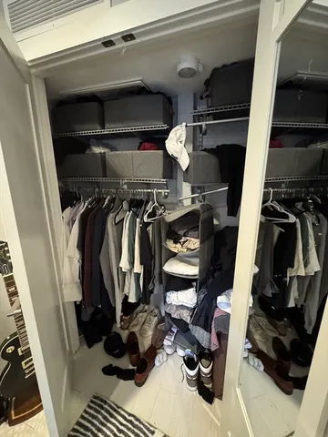 a view of walk in closet with clothes