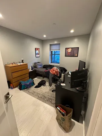 a living room with stainless steel appliances furniture a fireplace and a kitchen view