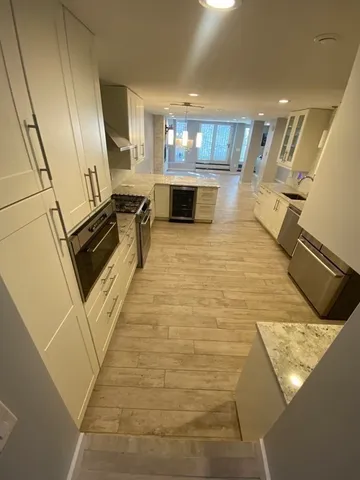 a kitchen with granite countertop a stove and a wooden floors