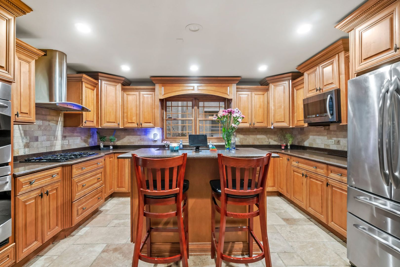 181 Herrick Road Riverside, IL 60546 - Photo 9 of 27 a kitchen with stainless steel appliances granite countertop wooden cabinets a center island and a window