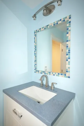 a bathroom with a granite countertop sink and a mirror