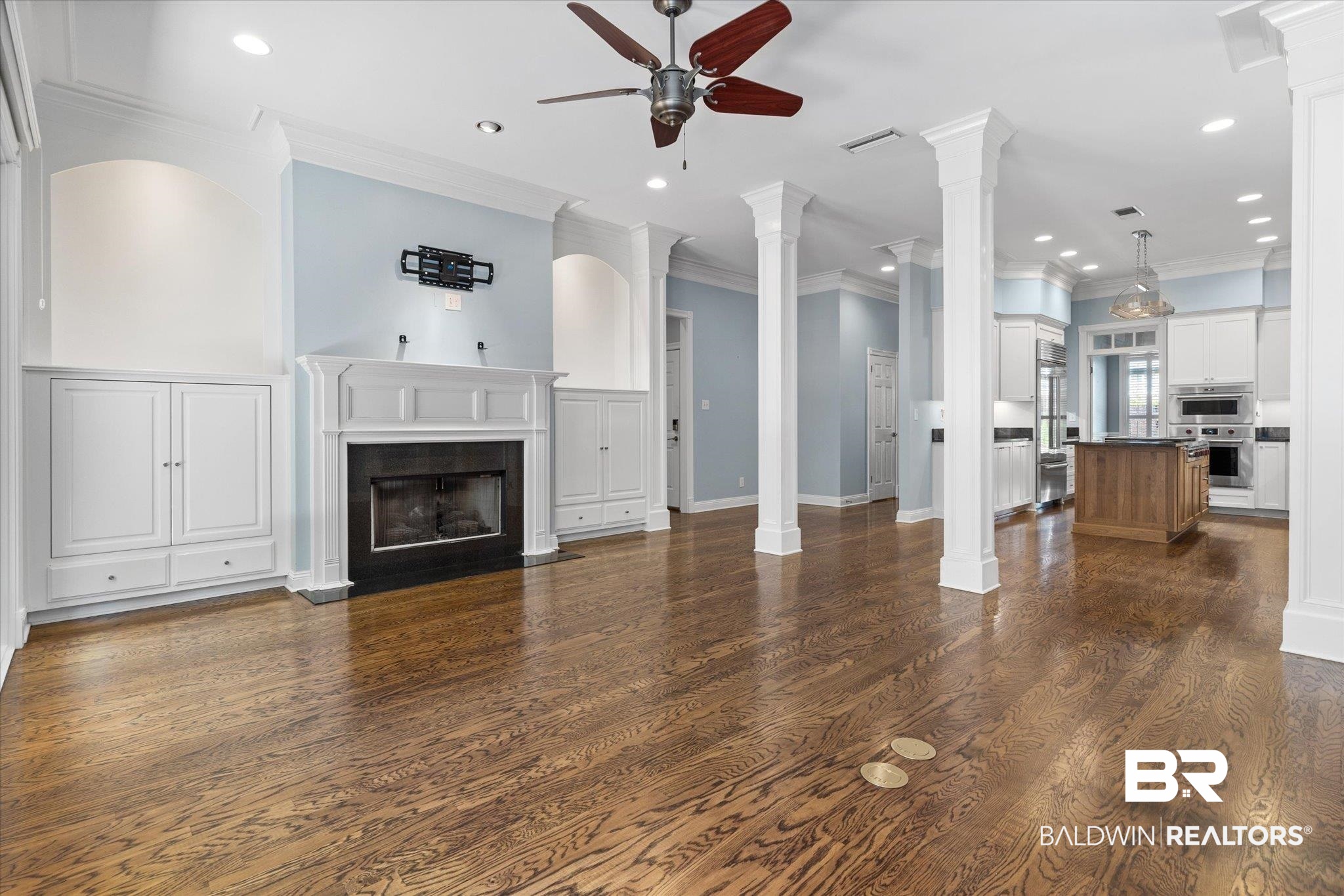 107 Fielding Place Mobile, AL 36608 - Photo 5 of 27 Unfurnished living room with ceiling fan, ornate columns, dark wood finished floors, a fireplace with flush hearth, and recessed lighting