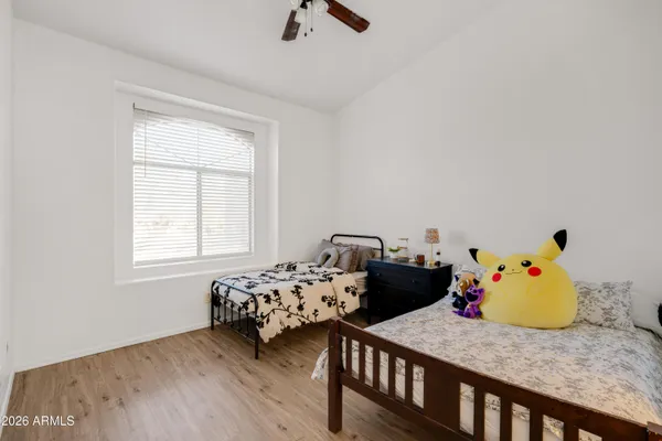 a bedroom with two beds and wooden floor
